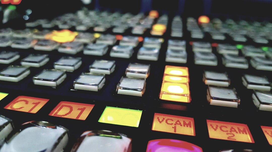 Close up of a video switcher panel with glowing buttons