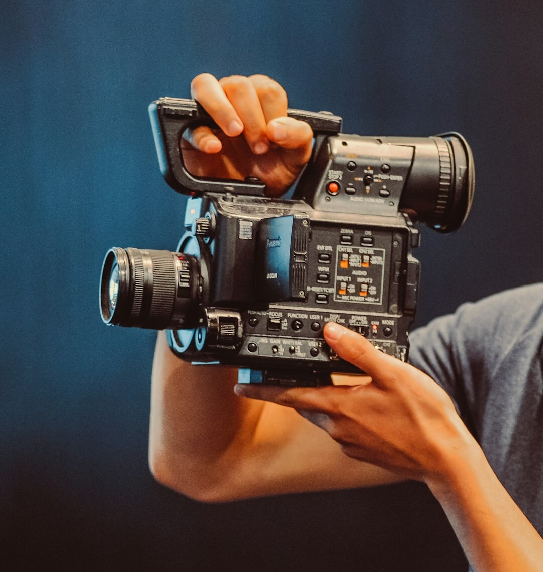Camera operator handling a professional broadcast camera in a TV studio